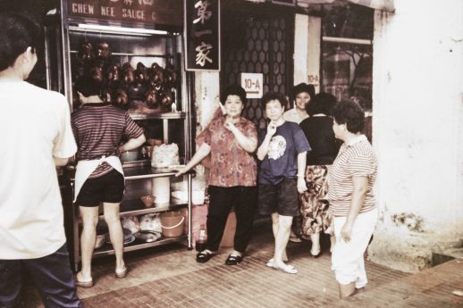Mdm Yu greeting customers at the Chew Kee stall, with soy sauce chickens on display